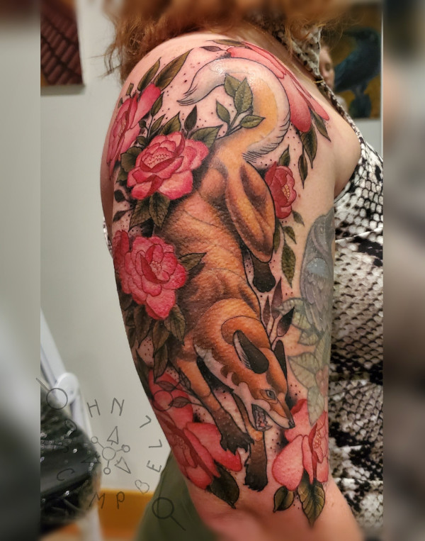 Full color upper arm tattoo of fox among roses by John Campbell at Sacred Mandala Studio tattoo parlor in Durham, NC.